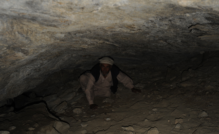 Abdul Karim saliendo de una pequeña cueva-abrigo